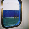 Pleasant view of a container ship in Auckland outside the porthole of a P&O cruise ship.