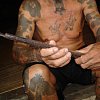 Unting, the shaman of the Iban people in a longhouse in Sarawak, holding tattoo equipment