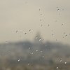 Sacre Coeur de Montmartre in the distance through a rain-splattered window at the top of the Pompidou Centre.