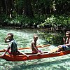 Three boys in a canoe on a river so clear they appear to be floating. Near Lopi Beach, Vanuatu.